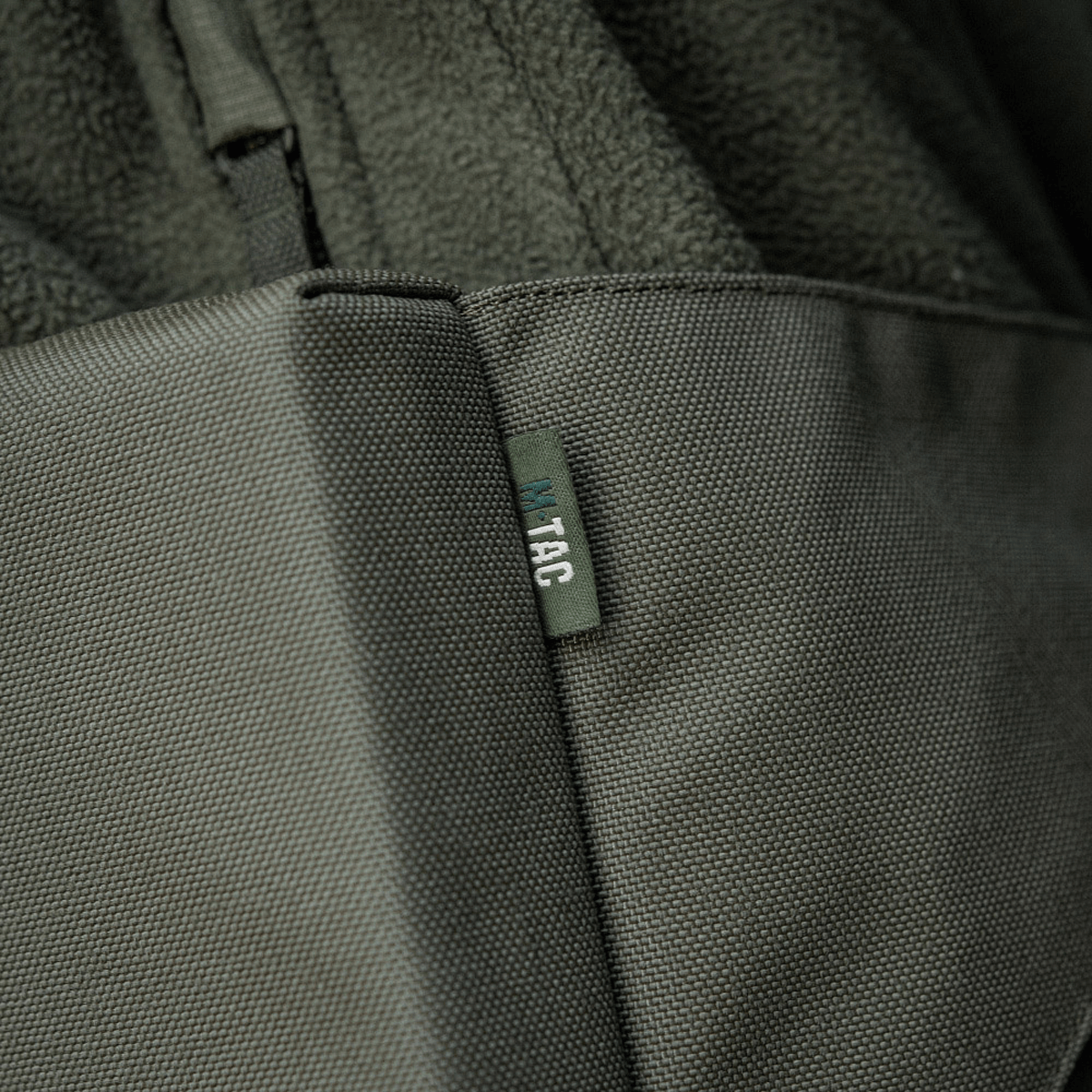 Nærbillede af M-Tac Siddeunderlag med bælte i grå stof med tydelig syning og M-Tac logo.