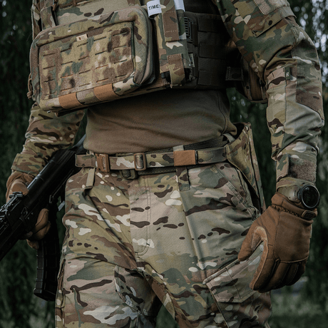 M-Tac sitteunderlag med belte – Multicam på soldat i feltklær, kamuflert for beskyttelse mot kulde og fukt.