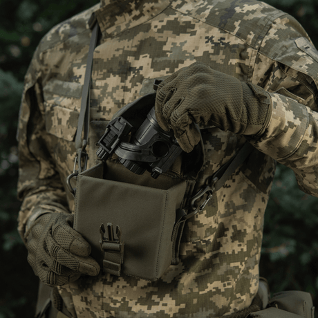 Soldat bruker M-Tac veske for nattkikkert PVS-14 i kamuflasjeuniform ute i naturen, viser praktisk oppbevaring for nattkikkerter.