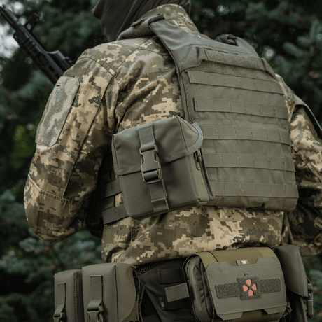 M-Tac veske for nattkikkert PVS-14 festet til en soldats uniform i skogmiljø.