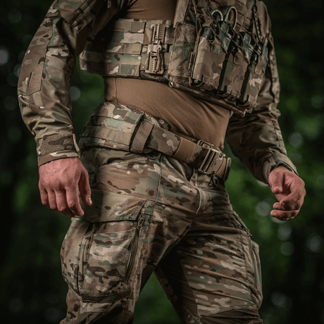 En soldat iført M-Tac War Belt ARMOR med MOLLE-webbing og robust lukning, ideel til taktisk brug i kampsituationer.