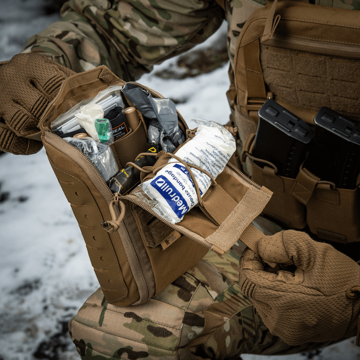 M-Tac Medical Pouch Elite Rip Off viser taktisk førstehjælpstaske i brug med åbningen af taskens håndtag og organiseret indhold.