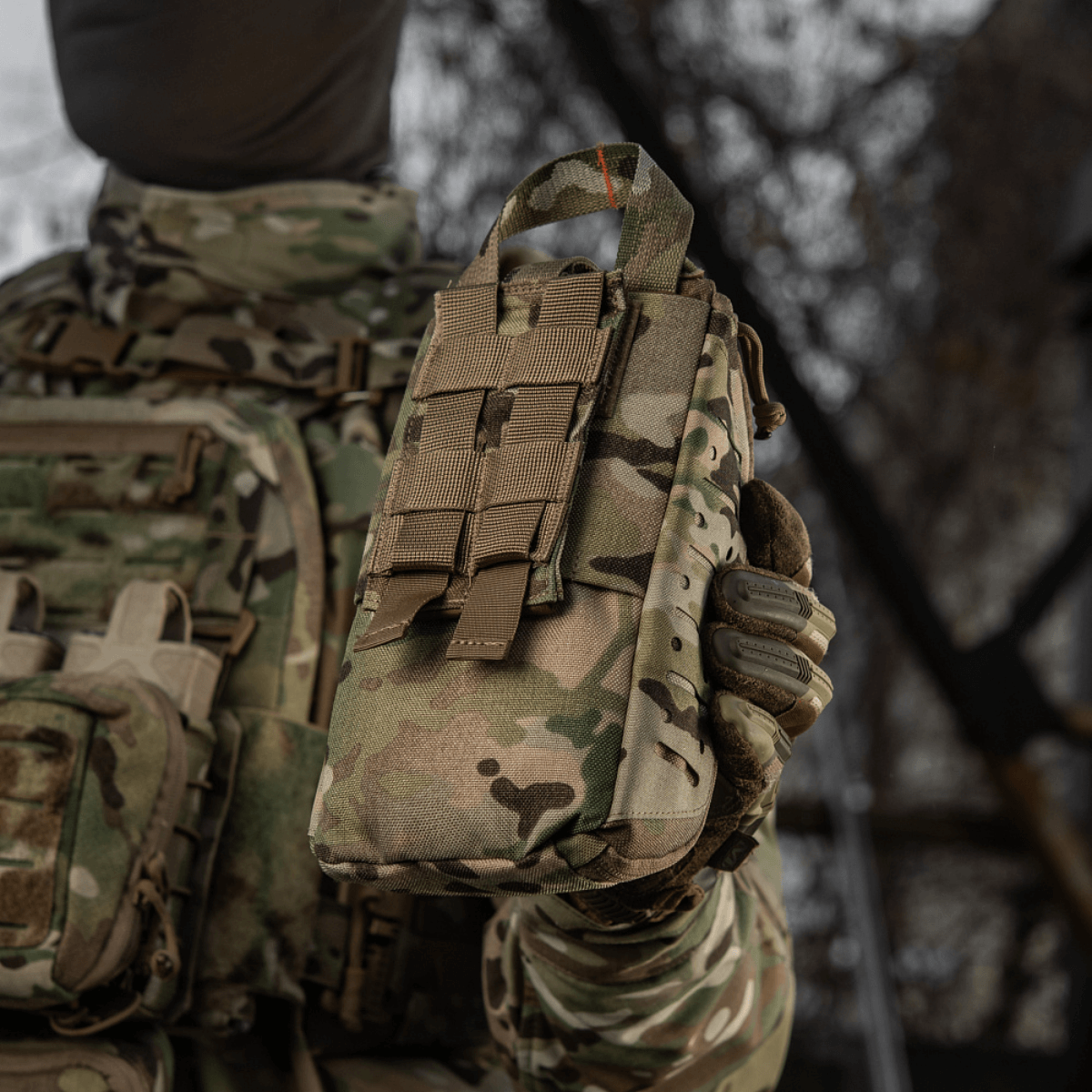 M-Tac Medical Pouch Elite Rip Off i camouflagetaske holdt af en soldat i taktisk udstyr udendørs, ideel til hurtig lægehjælp.