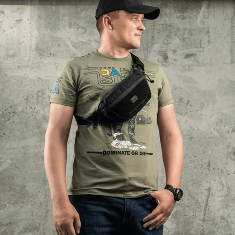 Mann iført M-Tac Tactical Waist Bag Gen.II Elite i svart, ideell for taktisk og hverdagsbruk, laget av slitesterkt Cordura 1000D-materiale