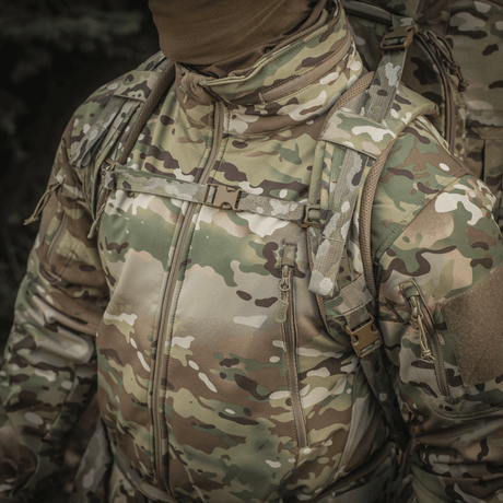 Camouflagejakke båret av en person som bærer M-Tac Ryggsekk Large Gen.III Elite, egnet for taktisk bruk og utstyrstransport.