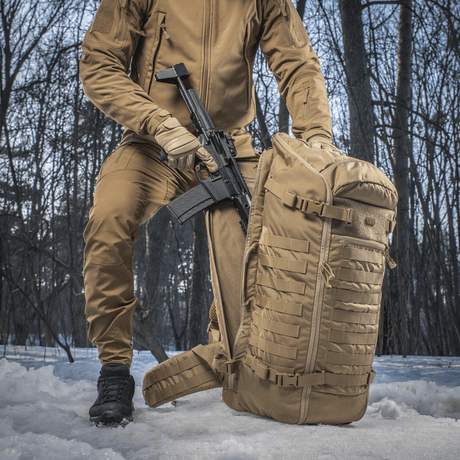 M-Tac Ryggsekk Gen.II Elite Large utendørs med stilrent design og våpenbærer, laget av slitesterkt Cordura i skogmiljø.