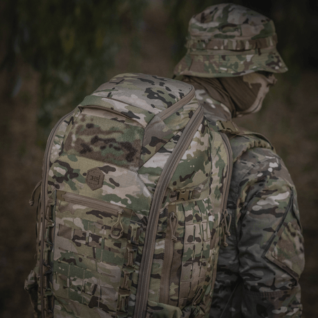 M-Tac Ryggsekk Large Gen.IV Elite i kamuflasjedesign brukt i utendørsmiljø, laget av slitesterkt Cordura for beskyttelse og holdbarhet.