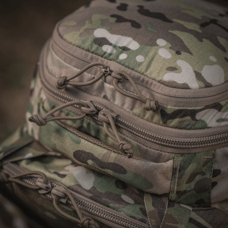Detalj av M-Tac Ryggsekk Large Gen.IV Elite i kamuflasje med robuste glidelåser, laget av slitesterkt Cordura for holdbarhet.