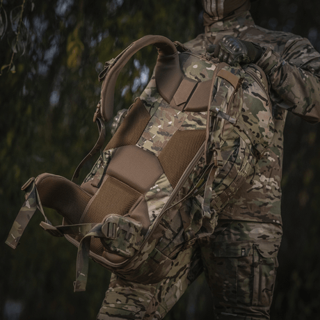 M-Tac Ryggsekk Large Gen.IV Elite i kamuflasjemønster, ergonomisk design, holdt av person i militærtøy i naturmiljø.