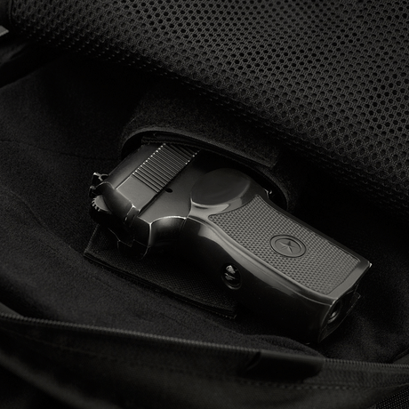 Innvendig lomme i M-Tac Magnet XL Bag Elite med universalhylster, vist med pistol, fremhever funksjonalitet og sikkerhet i vesken.