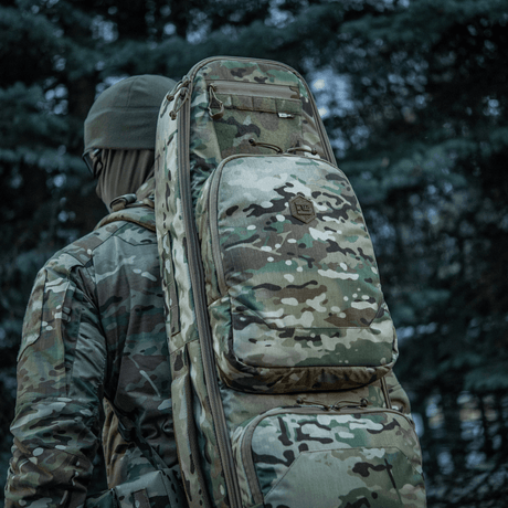 Jæger bærer camouflage M-Tac Gun Backpack Case 125 cm Gen.II Elite i skovområde