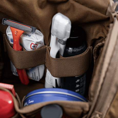 Nærbilde av M-Tac toalettmappe Elite Gen.II med barbermaskin, tannbørste og tannkrem. Kompakt og organisert oppbevaring for hygieneartikler.