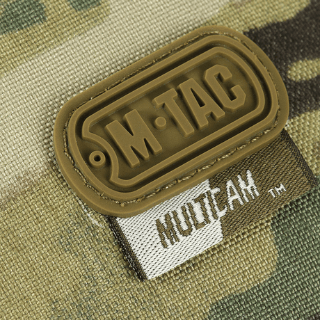 Nærbilde av M-TAC-logo på M-Tac toalettmappe Elite Gen.II med MultiCam-mønster.