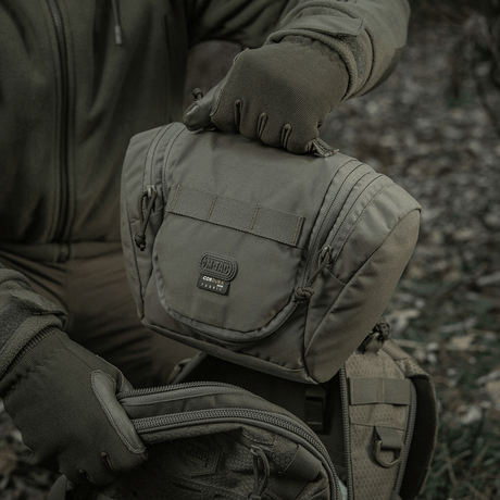 Person holder M-Tac toalettmappe Elite Gen.II designet for reiser og oppbevaring av toalettsaker i naturen.