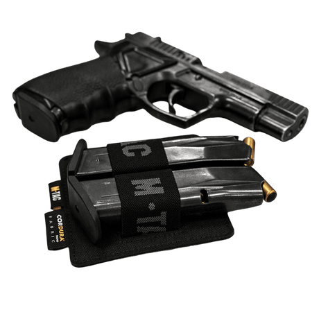 M-Tac Double Mag Pouch Hook Backed Magazine med to magasiner ved siden av en pistol på svart bakgrunn