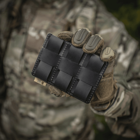 M-Tac panel for patches på MOLLE 120x85 med plastbase og hook & loop-overflate, ideelt for patches og ID, holdt av en soldat i kamuflasjetøy