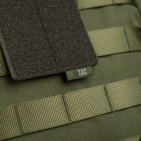 M-Tac panel for patches på MOLLE 80x135 med hook & loop-overflate og plastbase for stabilitet, montert på MOLLE-system