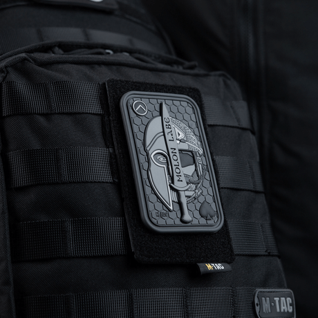 M-Tac panel for patches på MOLLE 80x135 festet på ryggsekk; hook & loop-overflate for patches og ID; plastbase for stabilitet