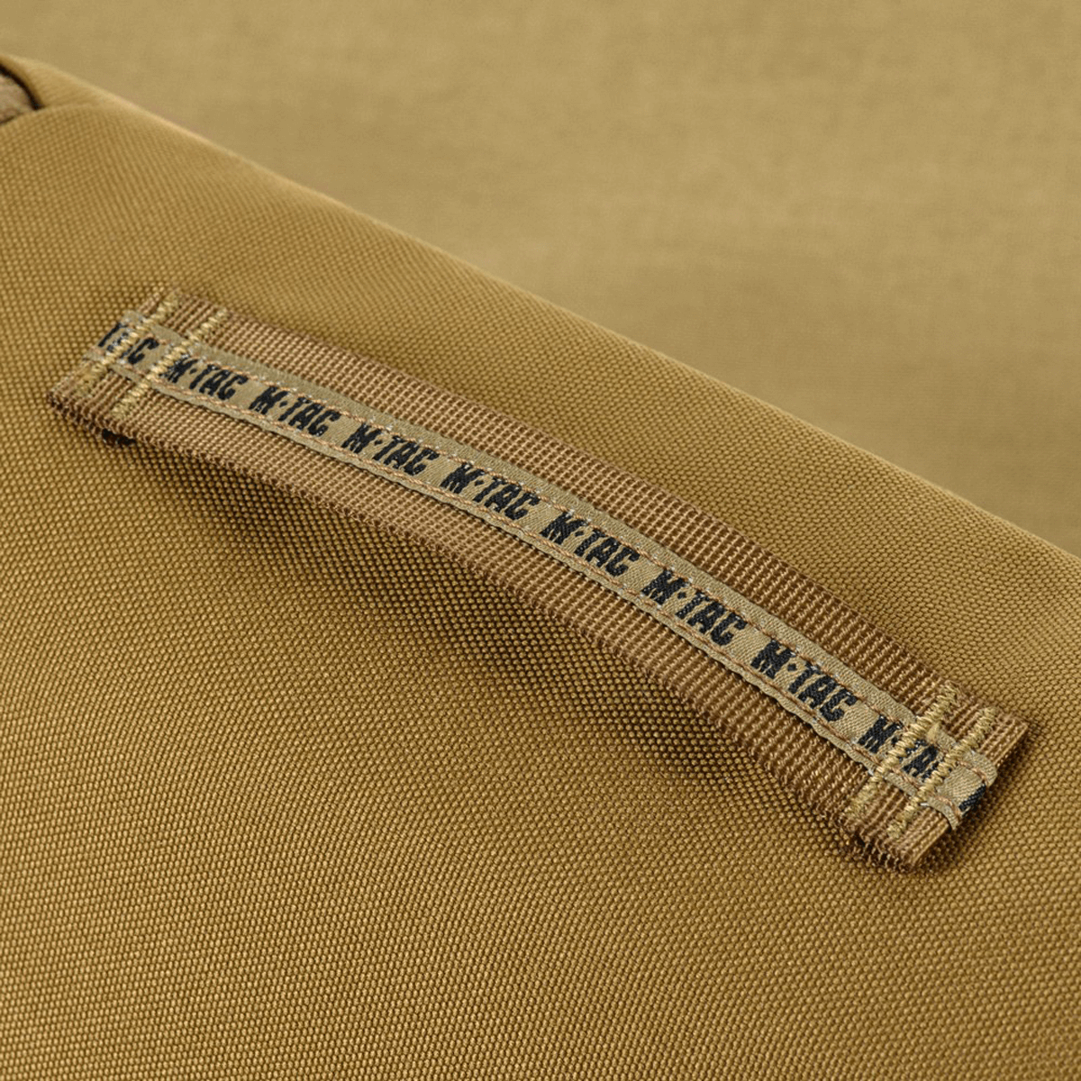 Nærbillede af gul M-Tac Toilettaske med slidstærk 600D polyester, fremhæver vandafvisende egenskaber og holdbarhed.