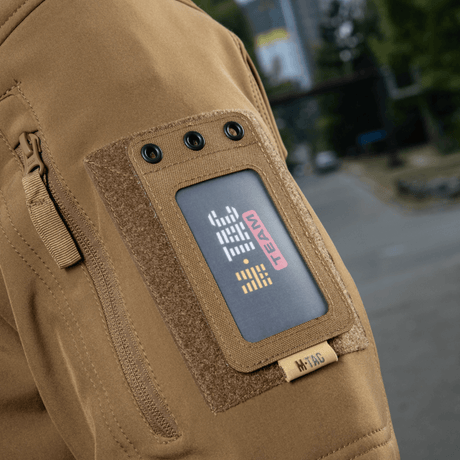 M-Tac taktisk ID-kortholder med snor på jakkeermet, solid Cordura, egnet for militær og taktisk bruk. "M-TAC TEAM" badge synlig.