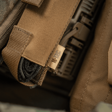 M-Tac Tourniquet Pouch Elastisk VELCRO Gen.II festet under plate carrier-flik med VELCRO for rask tilgang.