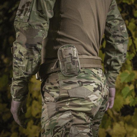 M-Tac PC Utility Pouch Elite festet på belte, MOLLE-system, kamuflasjebakgrunn, laget av slitesterk 500D Cordura. Perfekt for taktisk bruk.