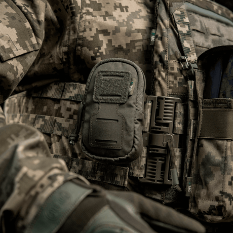 M-Tac PC Utility Pouch Elite festet på taktisk vest med MOLLE-interface og Velcro-panel, ideell for oppbevaring og drenering i bunnen
