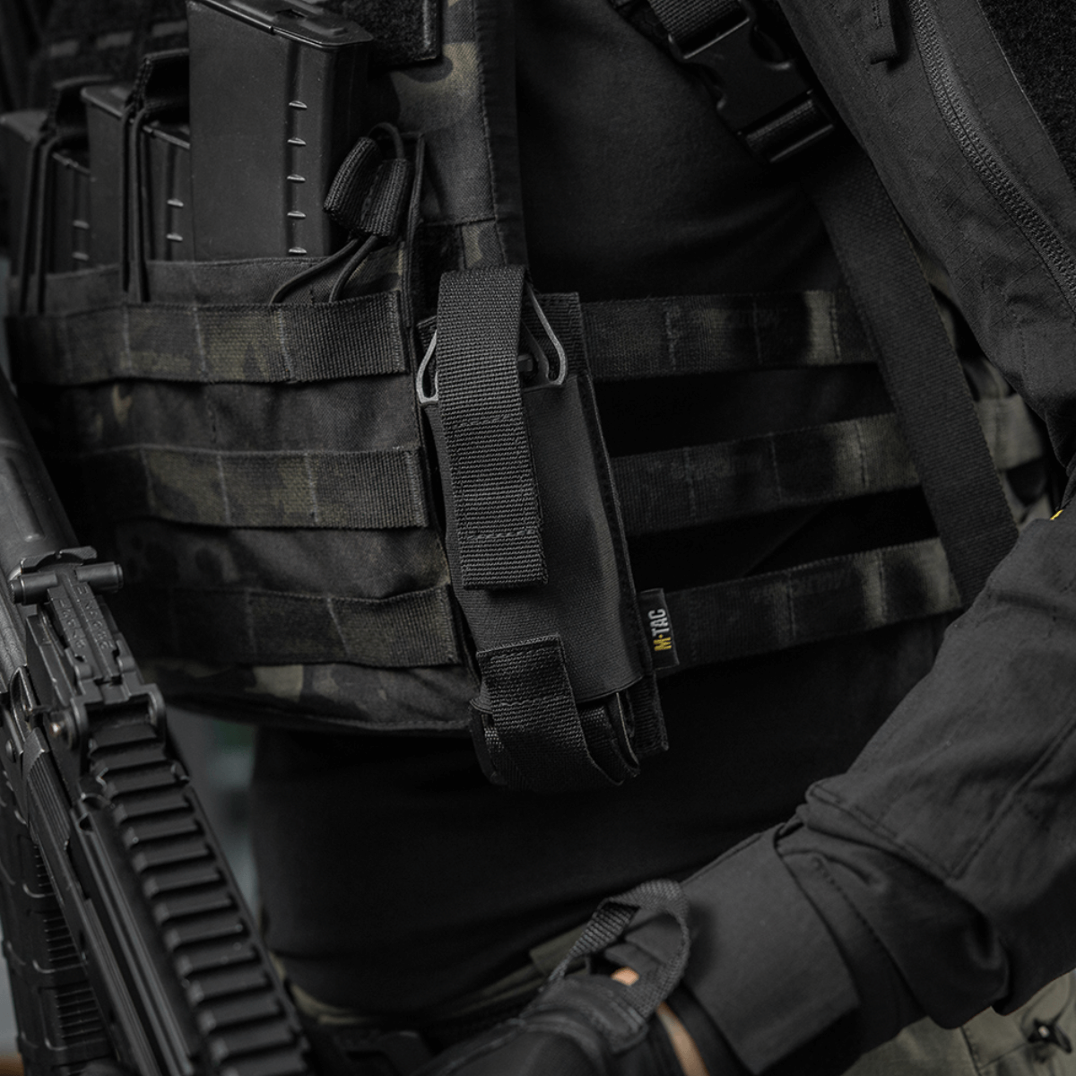 M-Tac Tourniquet Pouch Elastisk med MOLLE Gen.II fastgjort til taktisk udstyr, lavet af holdbar Cordura Squadron materiale.