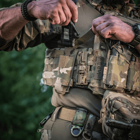 Soldat bærer M-Tac Tourniquet Pouch Elastisk med MOLLE Gen.II på militærutstyr i naturlige omgivelser.