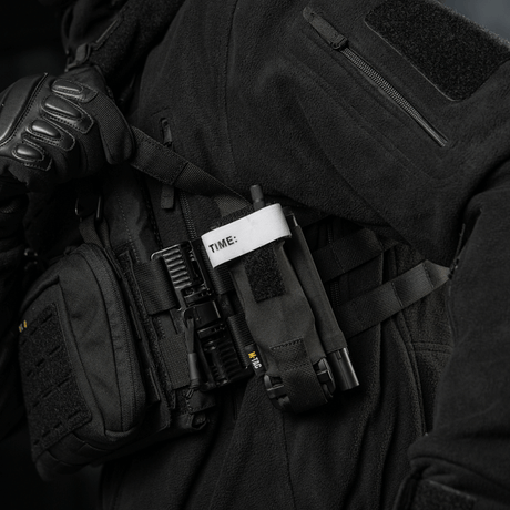 M-Tac Elastisk Tourniquet Pouch Molle Gen.III båret på taktisk utstyr, laget av Cordura, designet for rask tilgang til tourniquet.