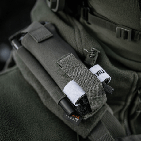 M-Tac Elastisk Tourniquet Pouch Molle Gen.III montert på jakke, laget av Cordura Squadron, med bred elastikk for C-A-T tourniquet.