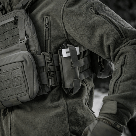 M-Tac Elastisk Tourniquet Pouch Molle Gen.III festet til taktisk jakke på person i feltet.
