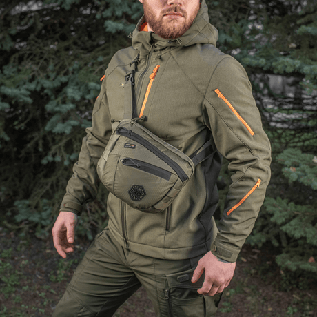 M-Tac Sphaera Hex Hardsling-veske Gen.II Elite på en mann iført militærgrønt tøy i naturen.