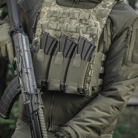 Person iført taktisk vest med M‑Tac Elastisk Triple Magazine Pouch Elite montert og AK-magasiner satt inn.