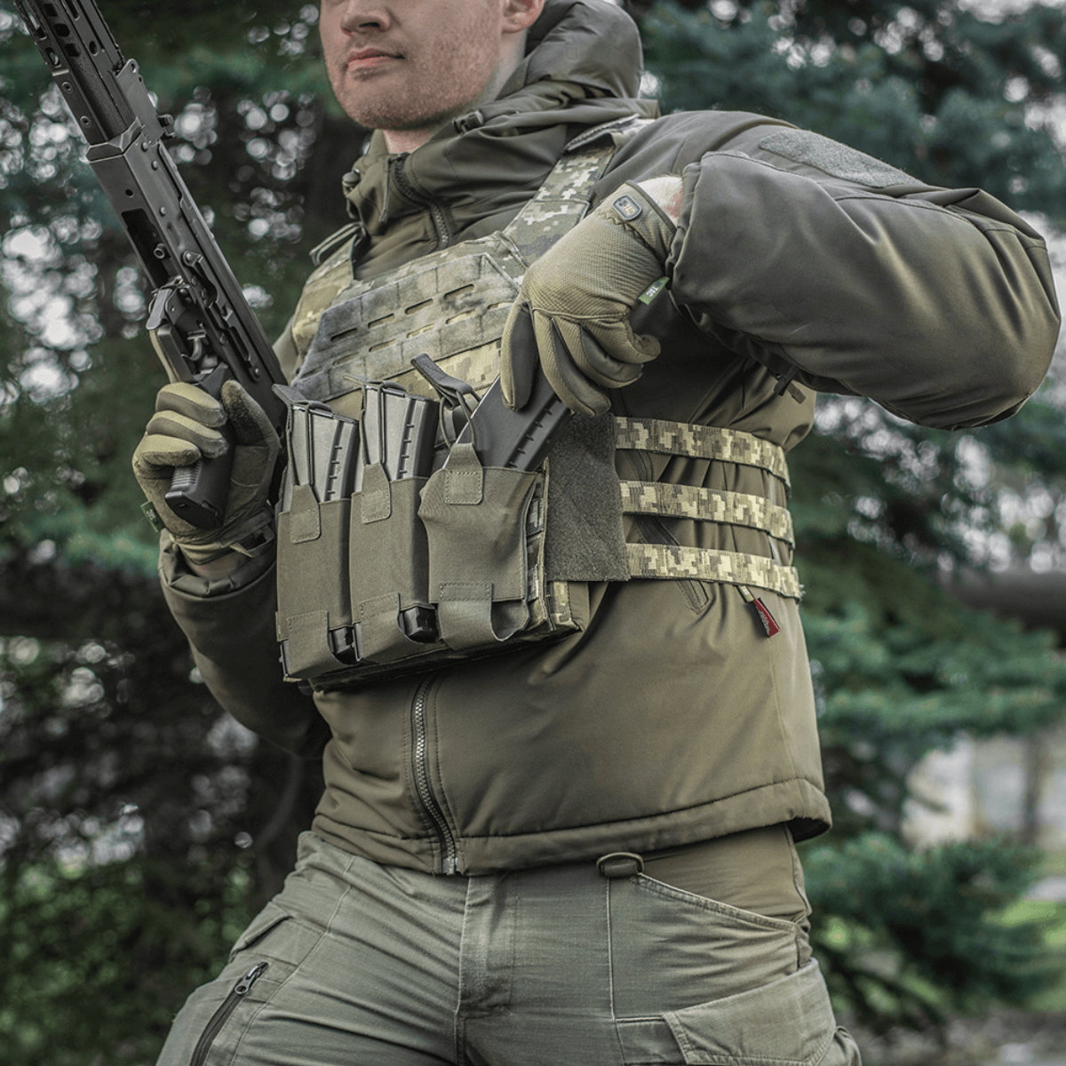 M‑Tac Elastisk Triple Magazine Pouch Elite monteret på taktisk vest for hurtig adgang til magasiner udendørs.