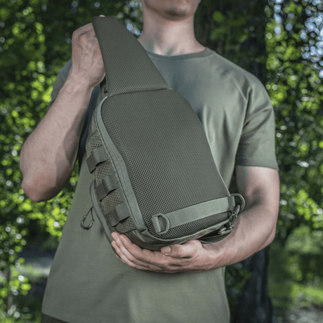Mann bærer M-Tac Cross Bag Elite Hex, en kompakt veske/ryggsekk i Cordura 500, ideell for daglig bruk og taktisk utstyr.