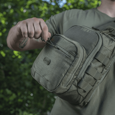 M-Tac Cross Bag Elite Hex-veske vist i bruk med slitesterkt Cordura 500-materiale og praktiske lynlåser, perfekt for daglig og taktisk bruk.