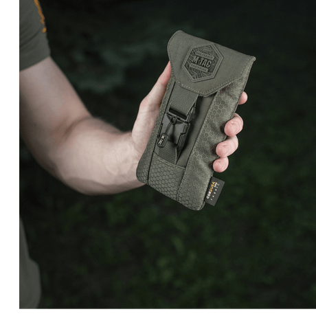 M-Tac Smartphone Lomme Elite Large Hex i hånden, laget av slitesterkt CORDURA HEX-materiale med WJ magnetisk spenne, svart design.