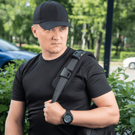 Mann bærer en ryggsekk med M‑Tac skulderrempute 50 mm Elite for komfort og vektfordeling.