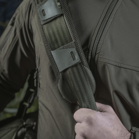 Mann bærer M‑Tac skulderrempute 50 mm Elite på skulderen for komfort og støtte.