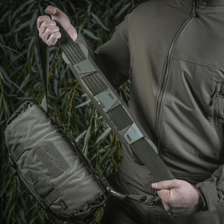 Mann holder M-Tac skulderrempute 50 mm Elite montert på veske.