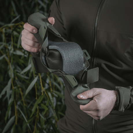 Person holder M‑Tac skulderrempute 50 mm Elite laget av slitesterkt Cordura med 3D mesh for komfort og vektfordeling.