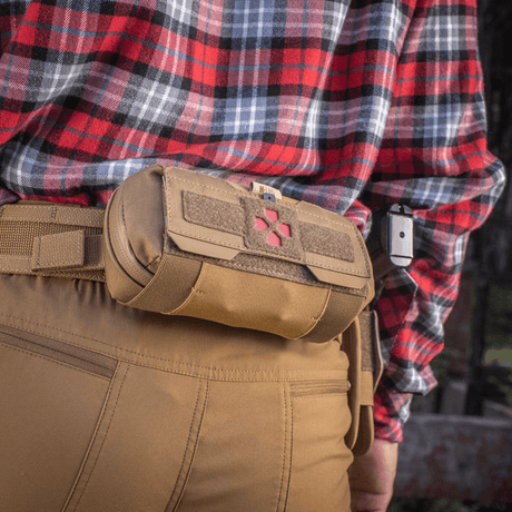 M-Tac Horizontal Medical Pouch Elite montert på belte, ideell for førstehjelp i felten, med slitesterkt Cordura og vanntett glidelås.