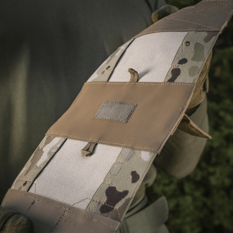 M‑Tac Horizontal Medical Pouch Elite festet på feltutstyr, viser slitesterkt Cordura 500D og YKK AquaGuard-glidelås, ideell for førstehjelp.