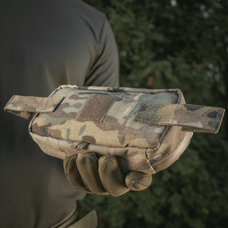 Person holder M‑Tac Horizontal Medical Pouch Elite i kamuflasje, ideell for feltbruk og førstehjelp, med robust design og vanntett glidelås.