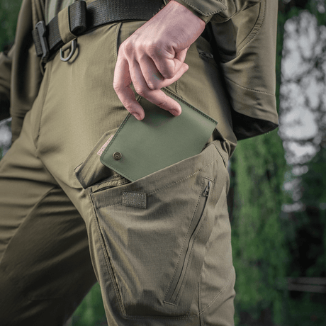 M-Tac Pung Slim Elite Gen. II i grønn, trekkes ut av bukselomme, viser kompakt design og moderne produksjonsteknologi.