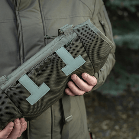 En person holder en M-Tac Taktisk Håndvarmer Elite lavet af holdbar Cordura 500D med fleecefor og G-Loft isolering til koldt vejr.