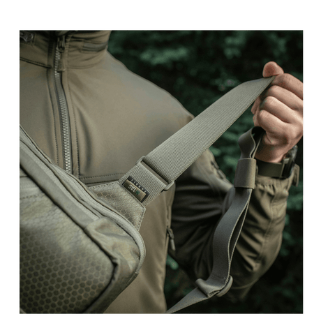 Mann bærer M-Tac Sling pistolveske Elite Hex med justerbar skulderrem i Cordura-materiale