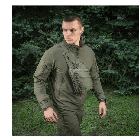 M-Tac Sling pistolveske Elite Hex båret av en person i utendørs omgivelser, viser veskeutforming og allsidighet.