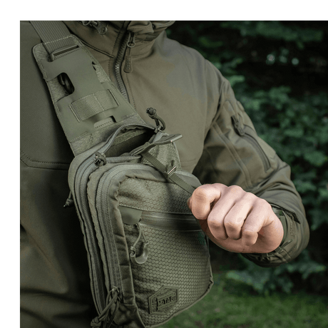 M-Tac Sling pistolveske Elite Hex med justerbar skulderrem på en person i utendørs miljø.